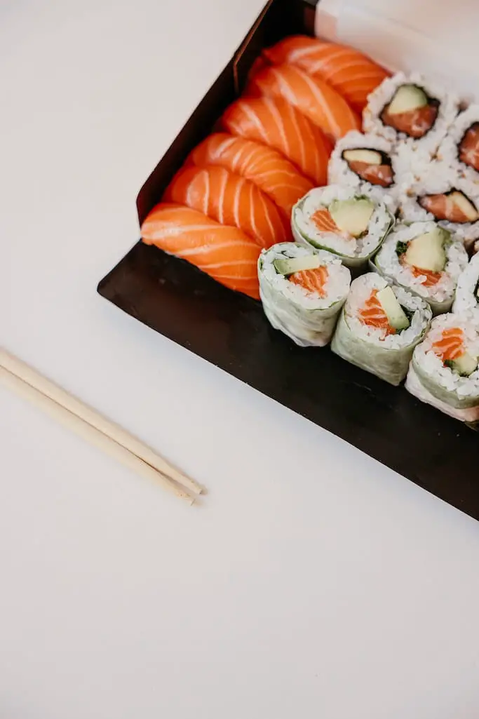 Sushi Box mit Lachs Nigiri und Summer Roll Maki und Essstäbchen