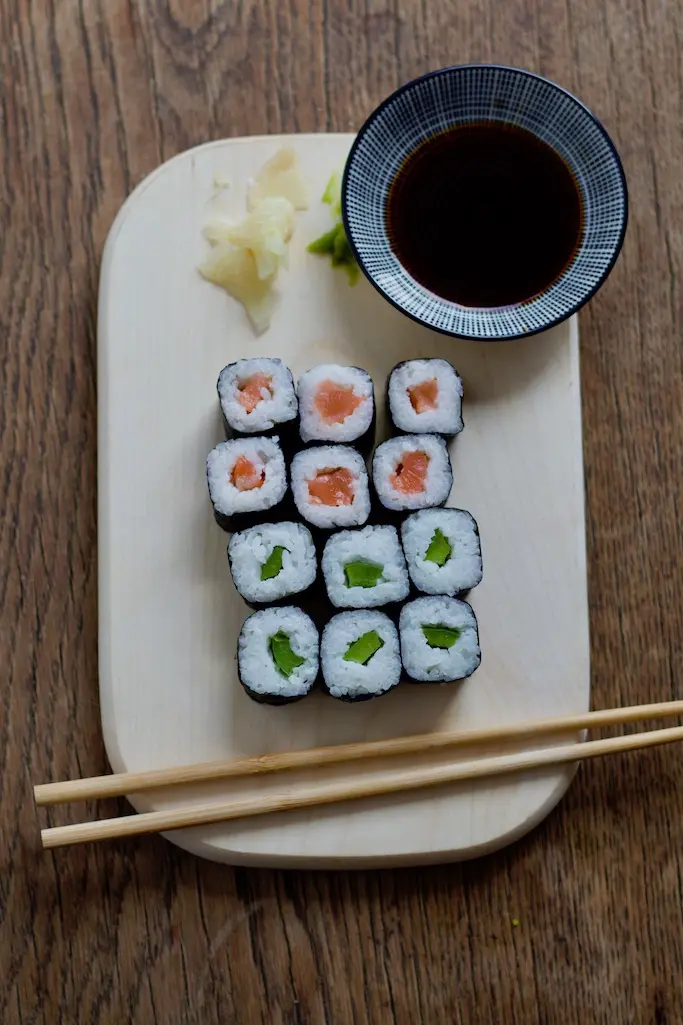 12 Stück Maki Sushi von Rewe liegen auf einem Holzbrett