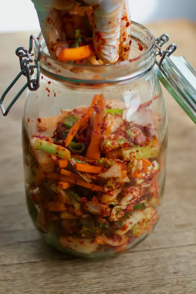 Kimchi in ein Einmachglas abfüllen