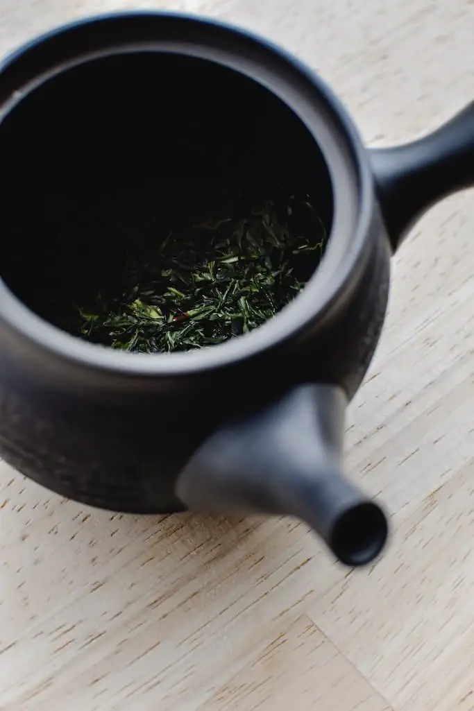Schwarze japanische Teekanne mit grünem Tee
